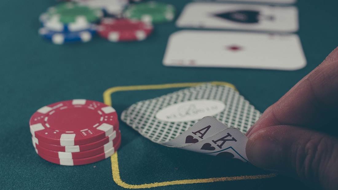 Kartu remi dan chip tersebar di atas meja hijau