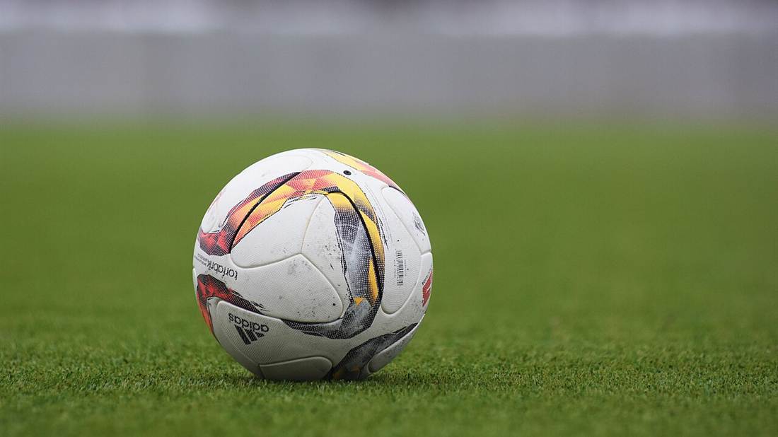 Bola sepak di atas rerumputan lapangan hijau